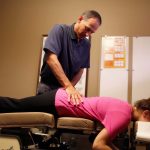 Woman receiving spinal adjustment