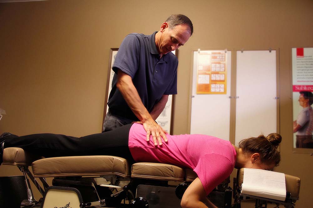 Woman receiving spinal adjustment